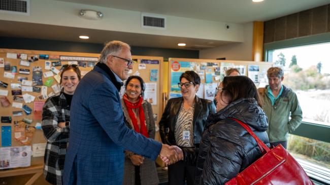 Gov. Jay Inslee shakes hands with a group of Anacortes residents.